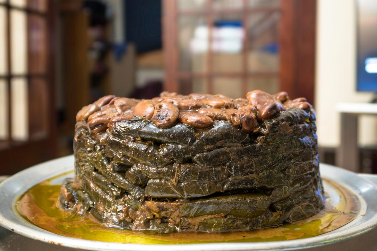 A layered tray of stuffed vine leaves cooked slowly in olive oil, showcasing a classic example of traditional yaprak sarma presentation. (Adobe Stock Photo)
