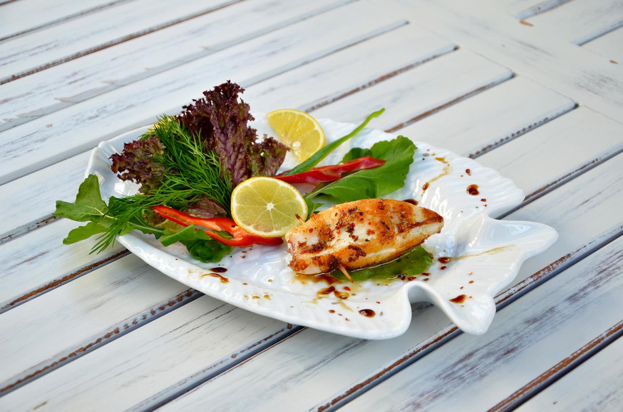 Stuffed calamari served with fresh greens and lemon, reflecting the seafood adaptations of dolma traditions along Türkiye’s coastal regions. (Adobe Stock Photo)