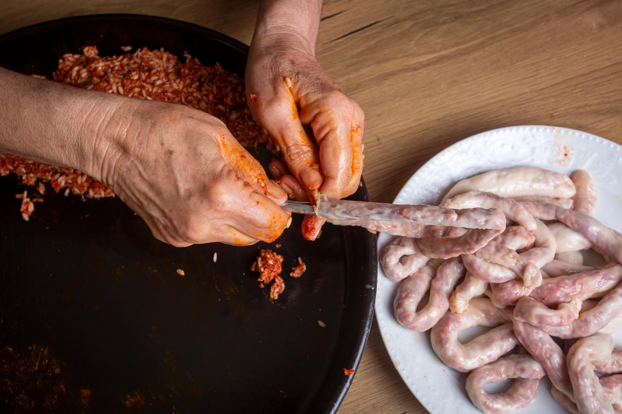 Traditional mumbar dolma being carefully filled by hand. (Adobe Stock Photo)