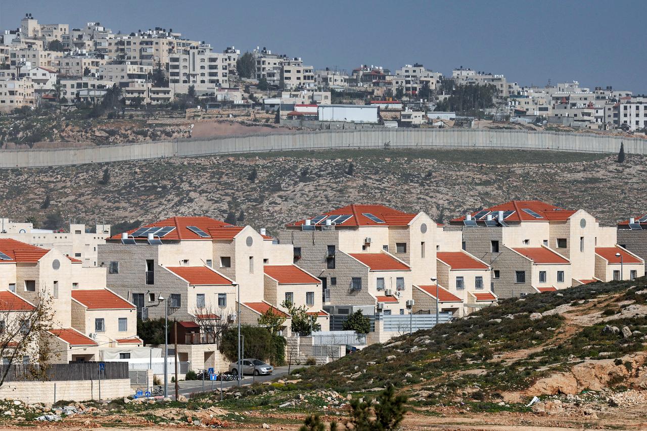 The Israeli settlement of Neve Yaakov (foreground) in the northern area of east Jerusalem and Israel's controversial barrier separating the Palestinian neighbourhood of al-Ram (background) are pictured in the occupied West Bank on February 16, 2026. (AFP Photo)