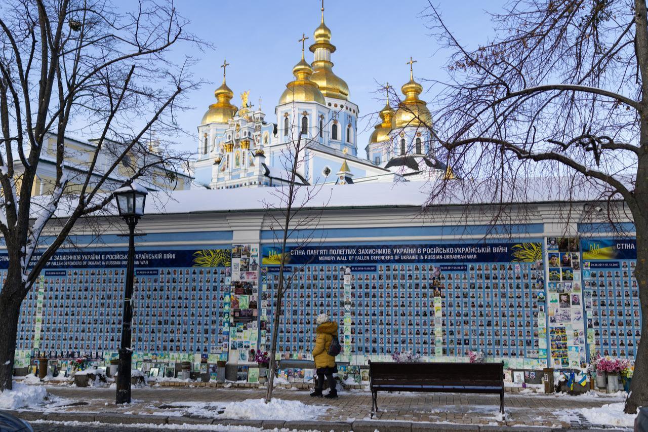 A woman walks alongside The Wall of Remembrance of the Fallen for Ukraine in Kyiv on February 17, 2026, amid the Russian invasion of Ukraine. (AFP Photo)
