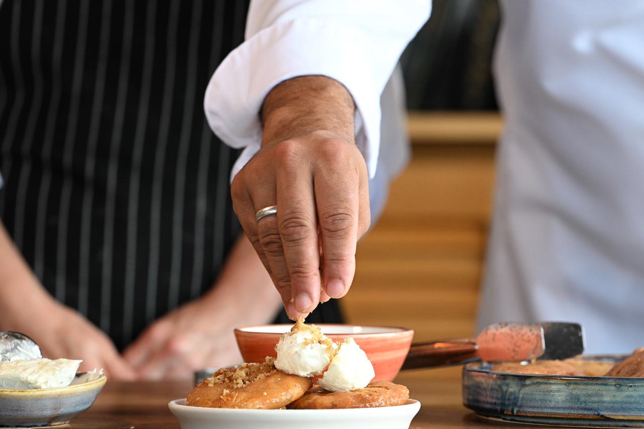 A chef adds cream and crushed nuts to Melenguccegi before serving at the Duzce Culinary Arts Center in Duzce, Türkiye, Feb. 18, 2026. (AA Photo)