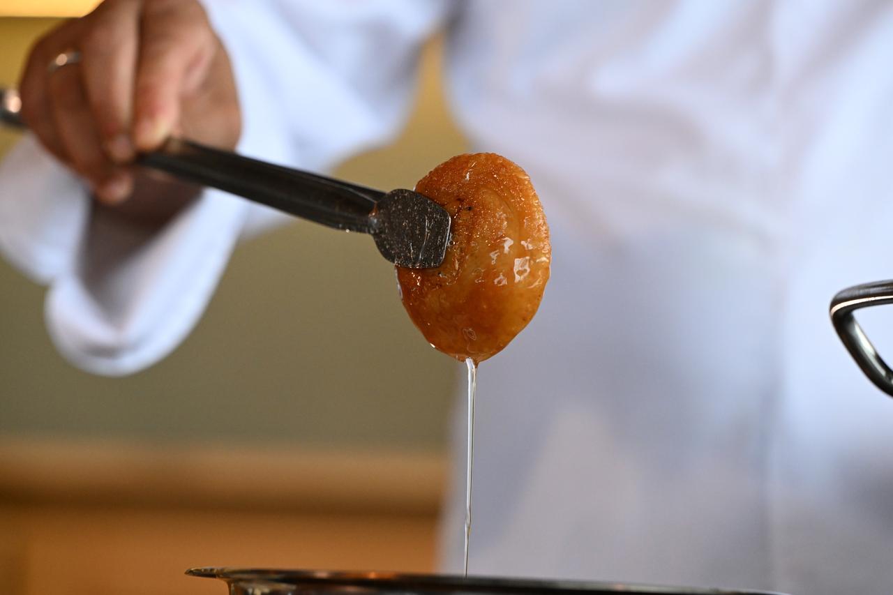 Freshly fried Melenguccegi is dipped into syrup as part of the traditional preparation process in Duzce, Türkiye, Feb. 18, 2026. (AA Photo)
