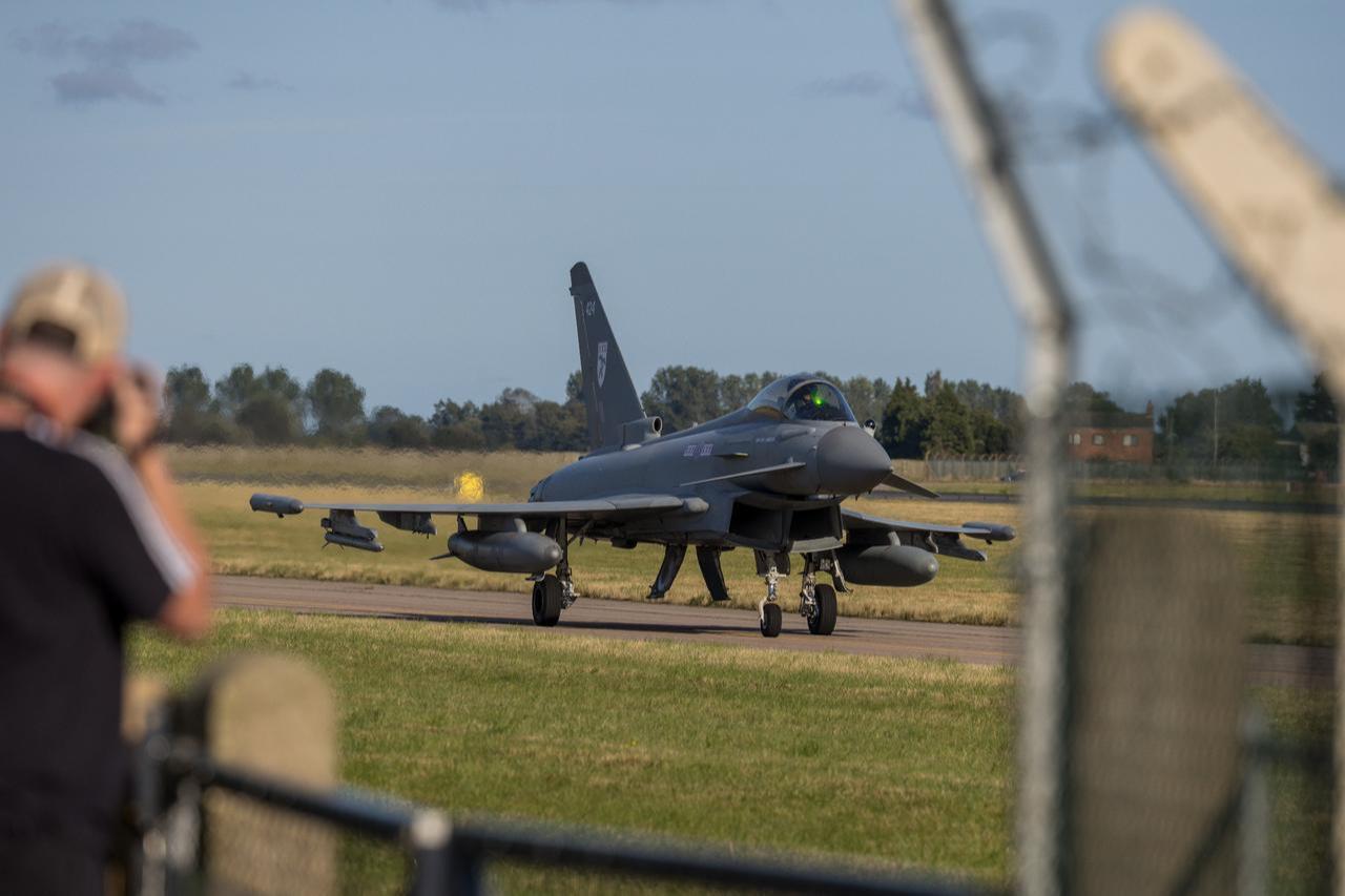 A Eurofighter Typhoon fighter jet taxis on the runway as an aviation enthusiast captures the moment at an unspecified location and time. (Adobe Stock Photo)