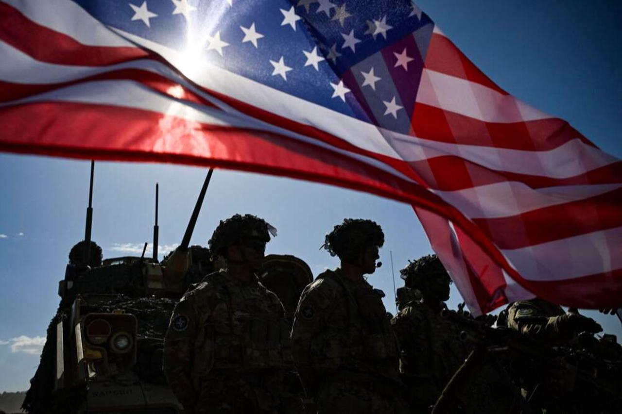 US Army soldiers stand in formation next to a US flag and a US Army armoured vehicle at the Novo Selo military ground, northwestern Bulgaria, Sept. 26, 2023. (AFP Photo)