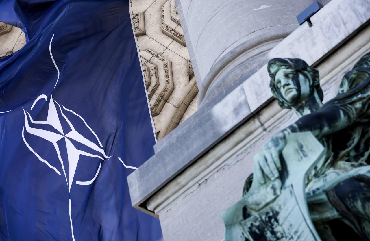 A NATO flag is pictured next to a statue on June 13, 2021 at Parc du Cinquantenaire in Brussels. (AFP Photo)