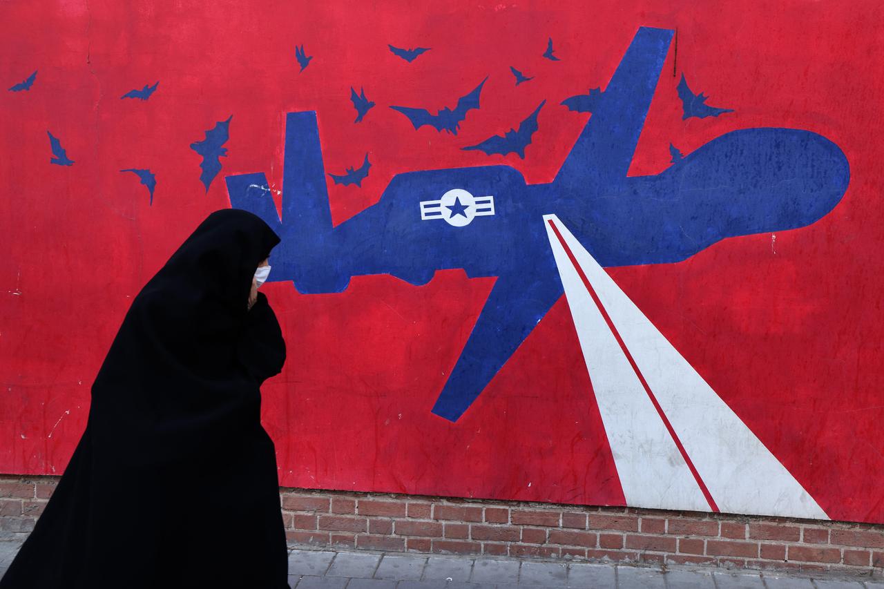 A woman walks past a mural depicting a US drone painted on the outer walls of the former US embassy in Tehran, colloquially-referred to as the "Spy Den,"on February 1, 2026. (AFP Photo)