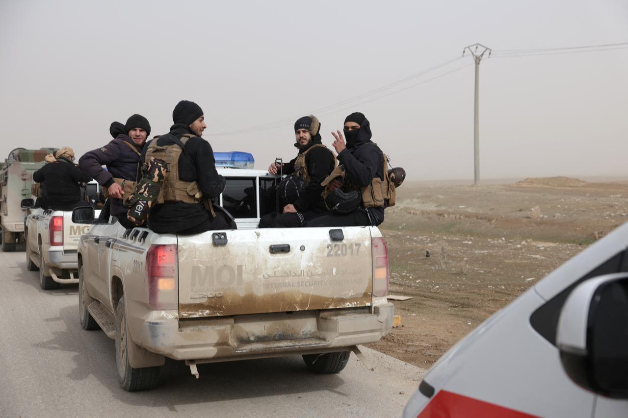 Members of the Syrian government forces sit in the back of trucks as they wait to start driving along a road in the countryside near the northeastern Syrian city of Hasakah, Feb. 2, 2026. (AFP Photo)