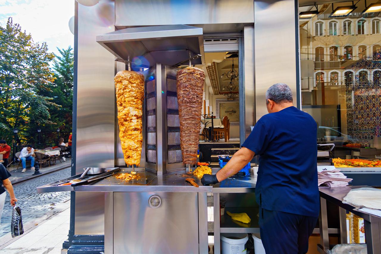 A doner kebab vendor prepares meat at a street-side restaurant in Istanbul, Türkiye. (Adobe Stock Photo)