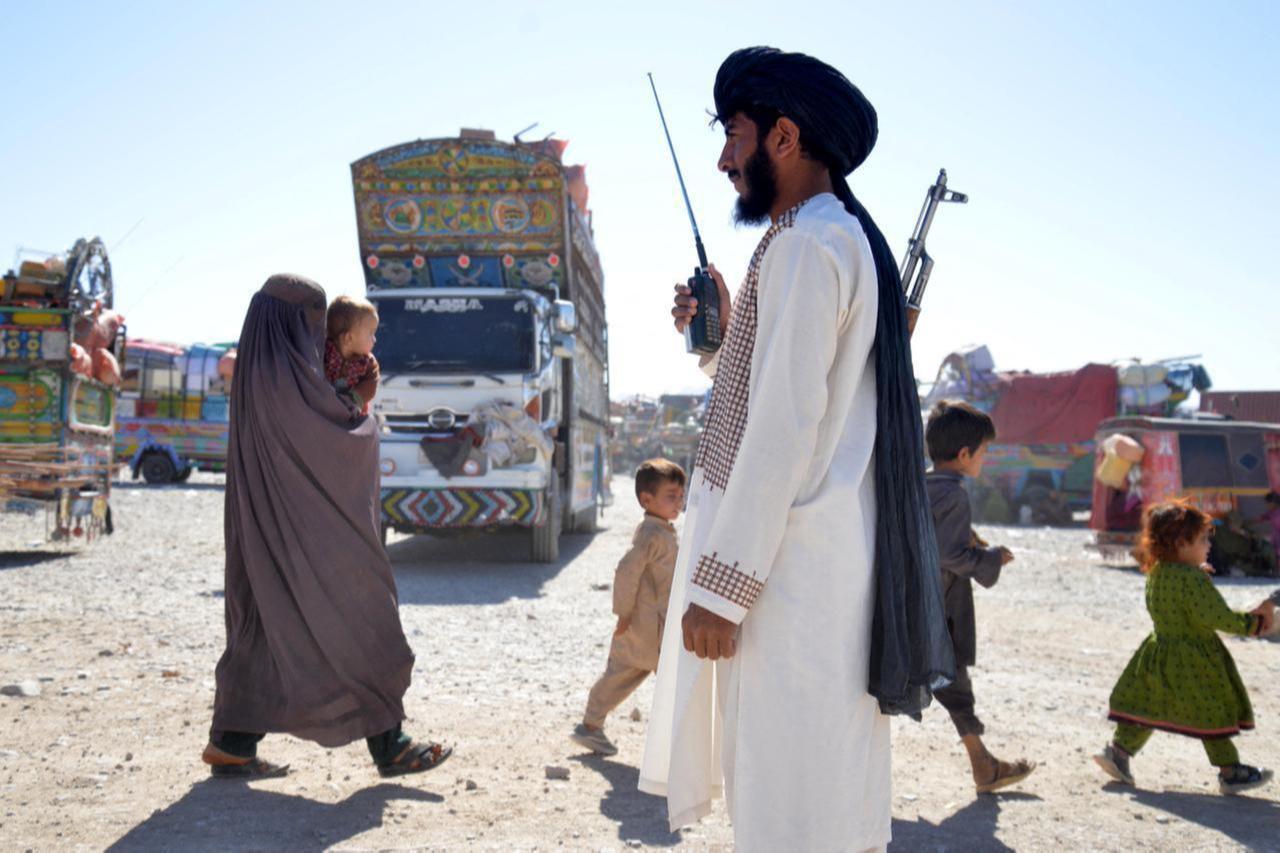 A Taliban security personnel stands guard as Afghans deported from Pakistan arrive at a registration centre at Takhta Pul in Kandahar province on Oct. 9, 2025. (AFP Photo)
