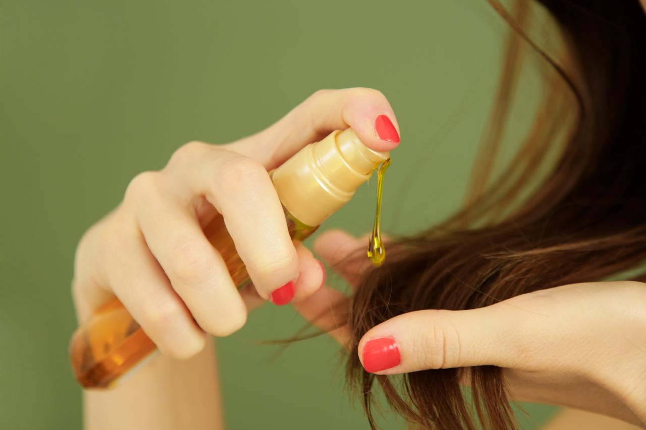 A person applies argan oil to hair as part of a moisturizing treatment commonly used in hair care routines, accessed on February 20, 2026. (Adobe Stock Photo)
