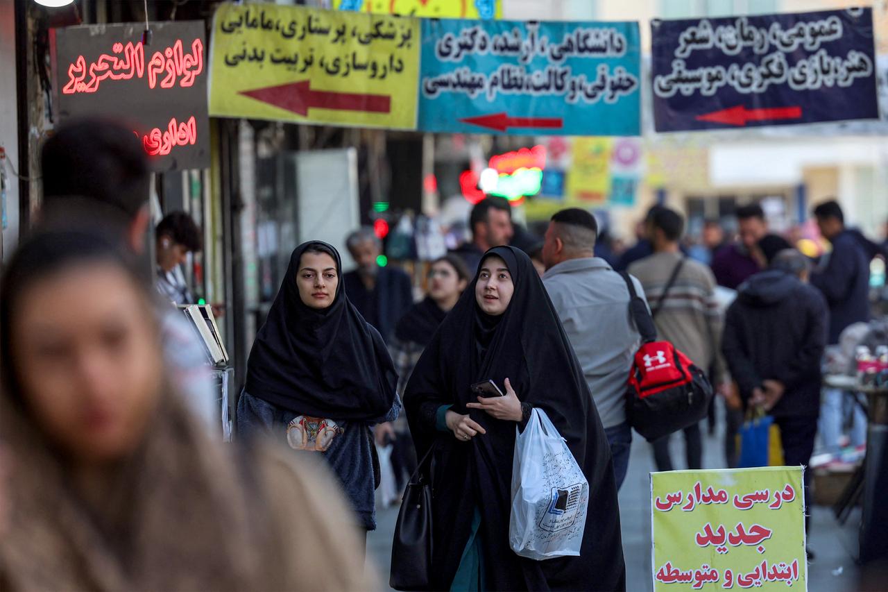 A woman walks along a main street in Tehran, February 21, 2026. (AFP Photo)