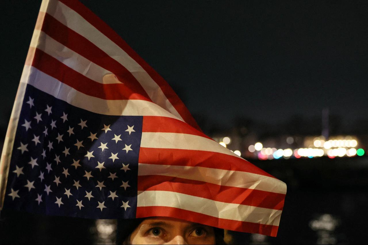 A protester holds a US flag during a rally against US President Donald Trump's policies in front of the National Assembly in Paris, France on January 28, 2026. (AFP Photo)