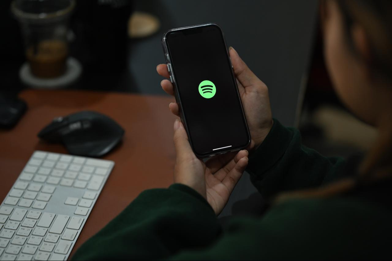 A person holding smart phone with Spotify on screen in Chiang Mai, Thailand on October 5, 2022. (Adobe Stock Photo)