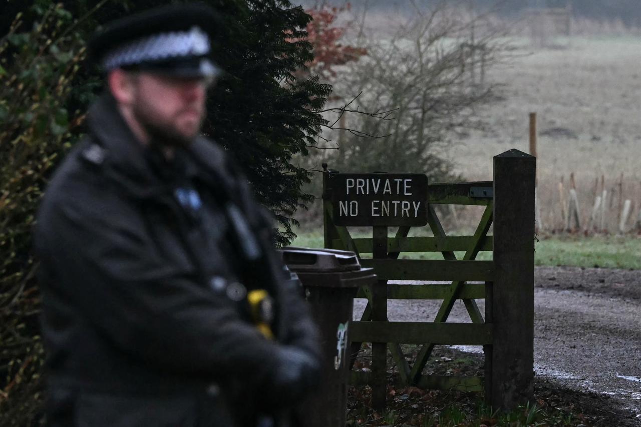 A policeman stands at an entrance to Wood Farm on the royal family's Sandringham Estate in Norfolk, eastern England on February 19, 2026, where former prince Andrew was arrested earlier in the day. (AFP Photo)