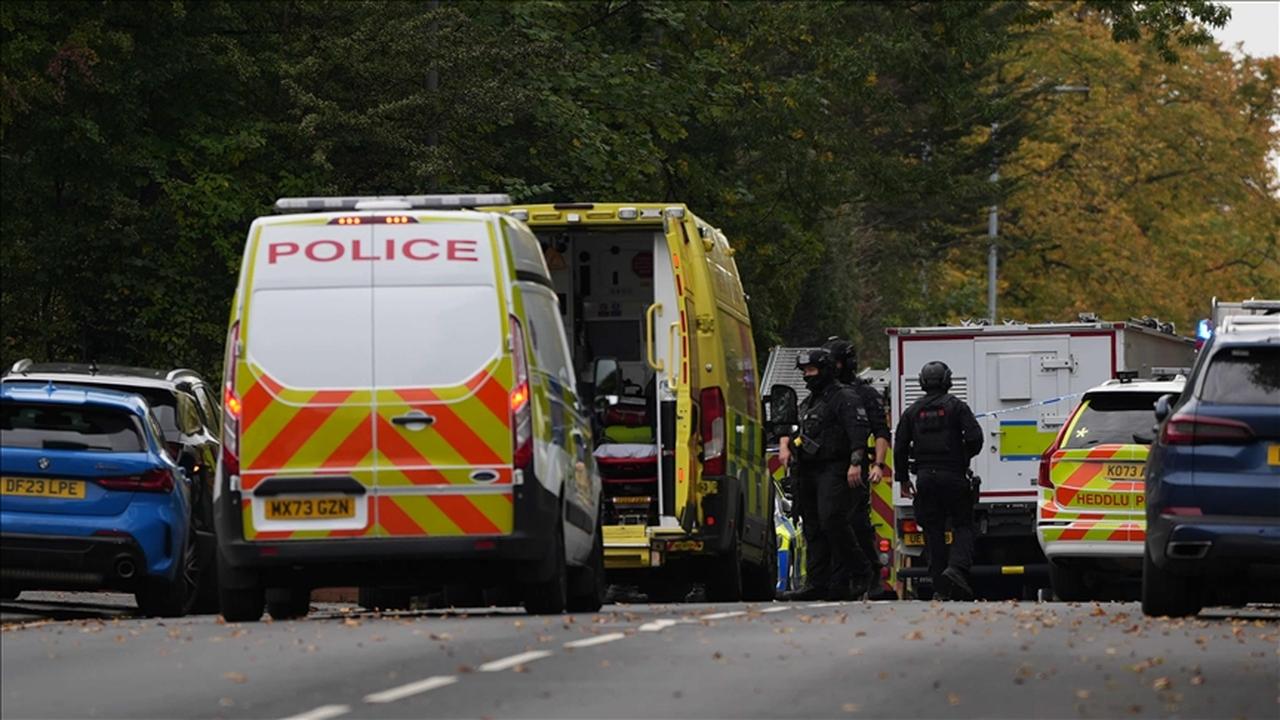 Police officers and emergency vehicles stand at a cordoned-off street in the U.K. (AA Photo)
