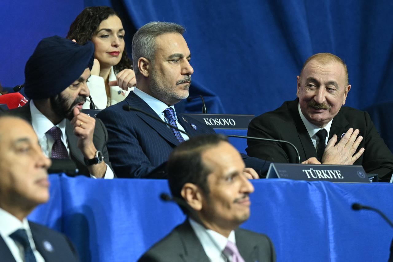 Azerbaijan's President Ilham Aliyev (R), sitting beside Turkish Foreign Minister Hakan Fidan, gestures as he is recognized by US President Donald Trump during the inaugural meeting of the "Board of Peace" at the US Institute of Peace in Washington, DC, on February 19, 2026. (AFP Photo)