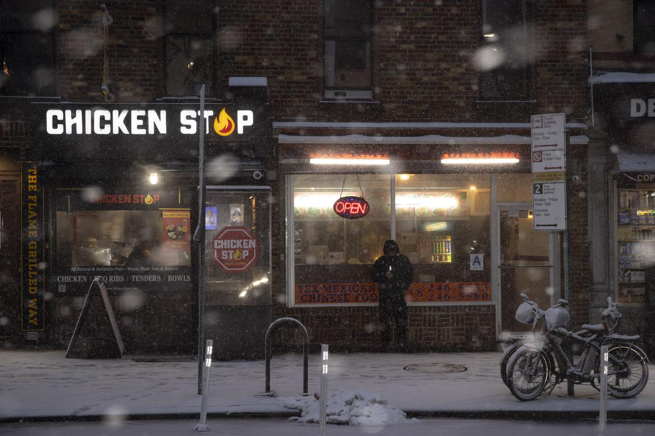 A person stands outside a restaurant in Brooklyn as New York City braces for a blizzard, Feb. 22, 2026. (AA Photo)