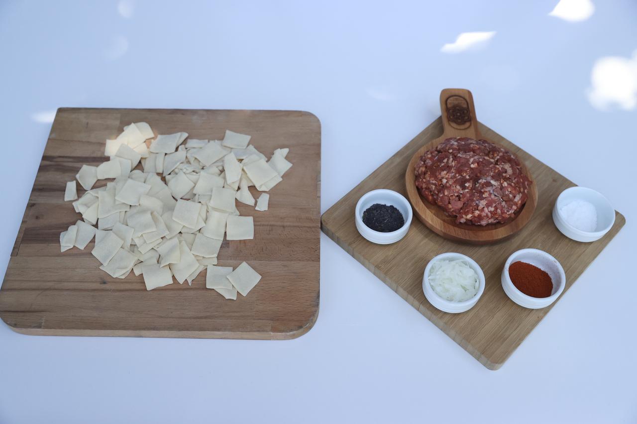Ingredients including minced meat, spices, and dough pieces are prepared for tepsi mantisi in Kayseri, Türkiye, Feb. 22, 2026. (AA Photo)