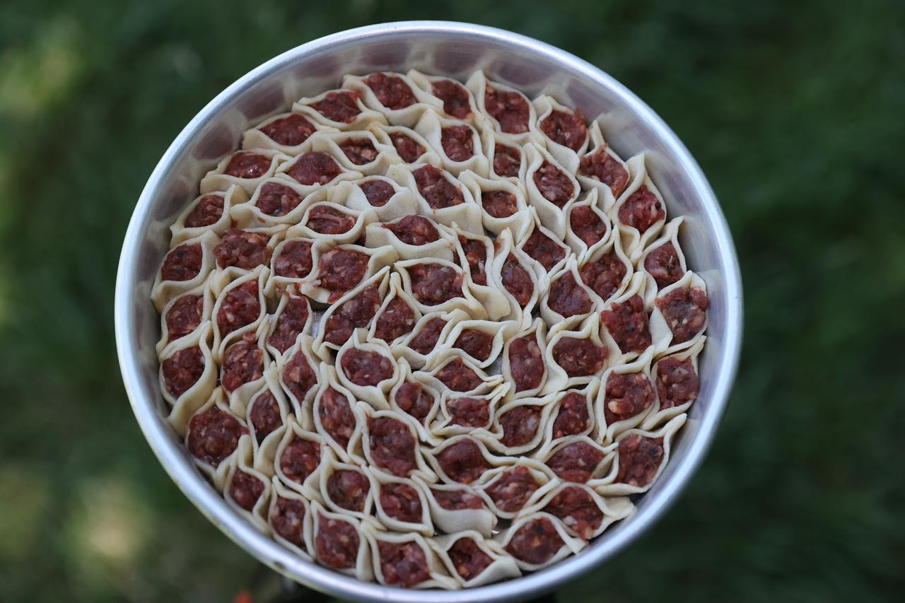Uncooked tepsi mantisi dumplings are lined up closely in a tray before baking in Kayseri, Türkiye, Feb. 22, 2026. (AA Photo)