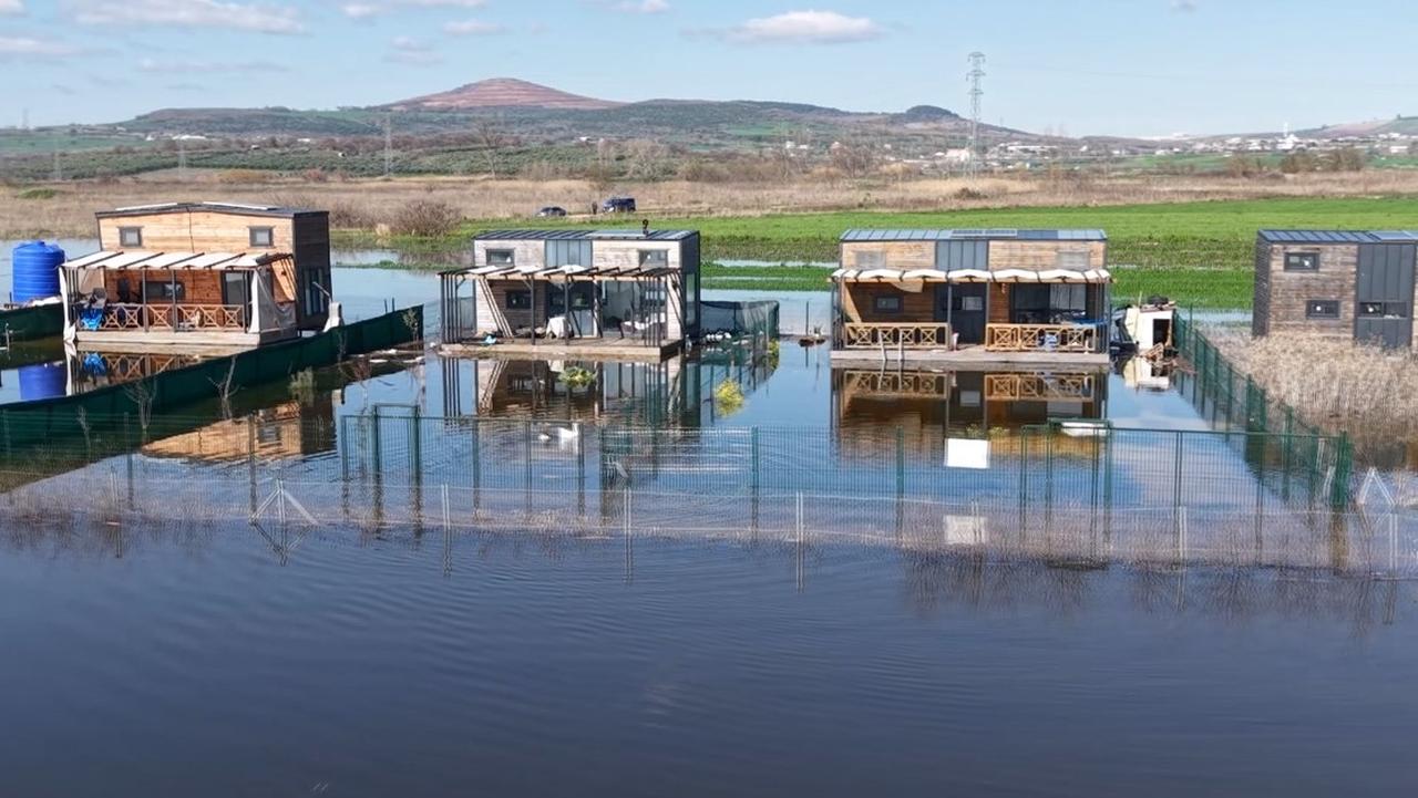 Floodwaters surround tiny houses and bungalows after rising water levels at Uluabat Lake overflow into residential and agricultural areas near Bursa, Türkiye, Feb. 24, 2026. (IHA Photo)
