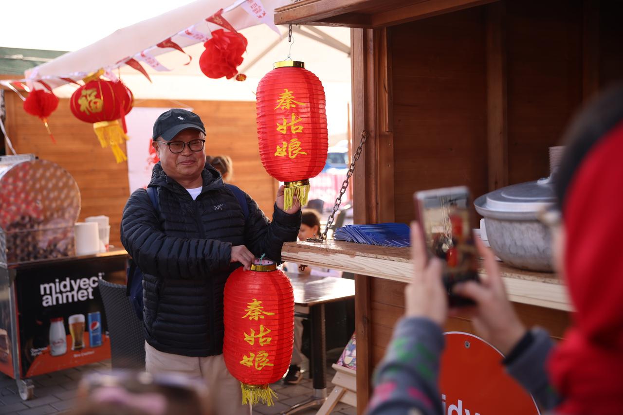 A visitor poses with traditional Chinese lanterns at a festival area set up for Year of the Horse events in Cappadocia, central Türkiye, February 2026. (AA Photo)