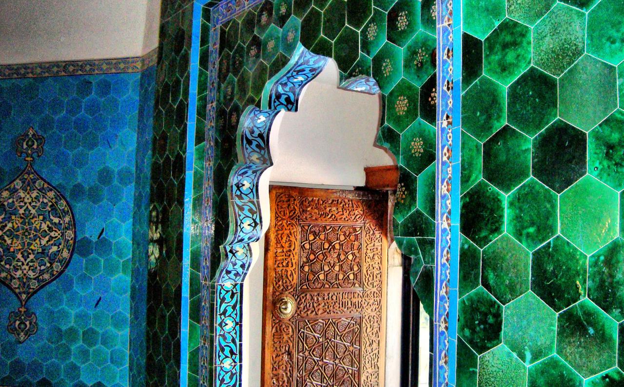 Interior detail from the Yesil Turbe (Green Tomb) in Bursa, featuring ornate Iznik tiles and decorative architectural elements surrounding the mausoleum of Sultan Mehmed I. (Image via Wikimedia)