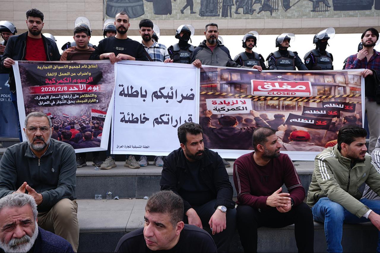 Iraqi traders and shop owners hold banners during a protest against new customs tariffs and the ASYCUDA digital customs system in Baghdad, Iraq, Feb. 8, 2026. (AA Photo)
