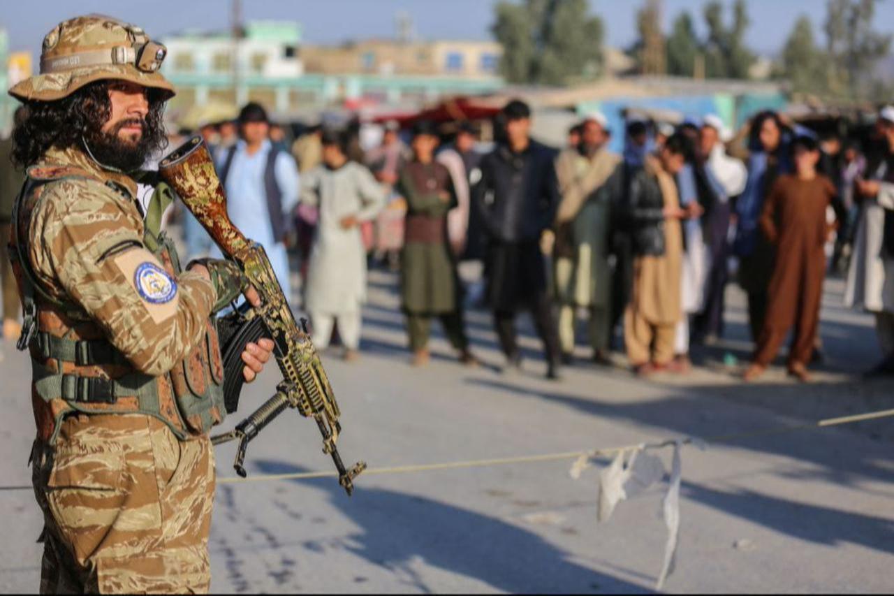 A Taliban security personnel stand guard as Afghan people wait to cross into Pakistan, near the closed Torkham gate at the Torkham border crossing between Afghanistan and Pakistan, in Nangarhar province, Feb. 23, 2023. (AFP Photo)