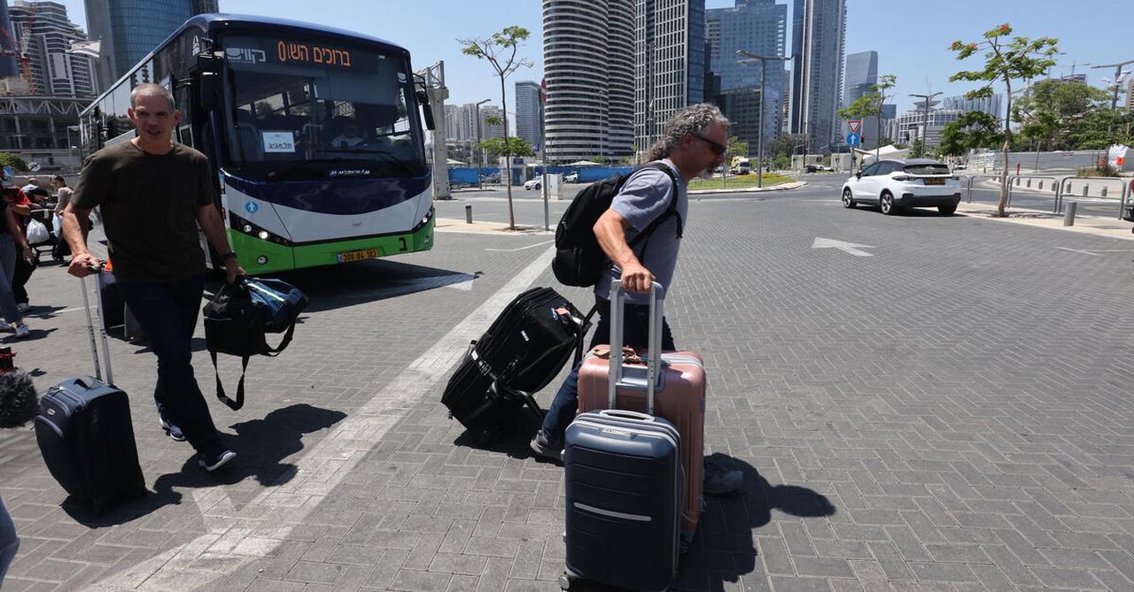 Israelis disembark a bus after they were flown back to Israel in a special flight, on June 18, 2025, in Tel Aviv. (AFP Photo)
