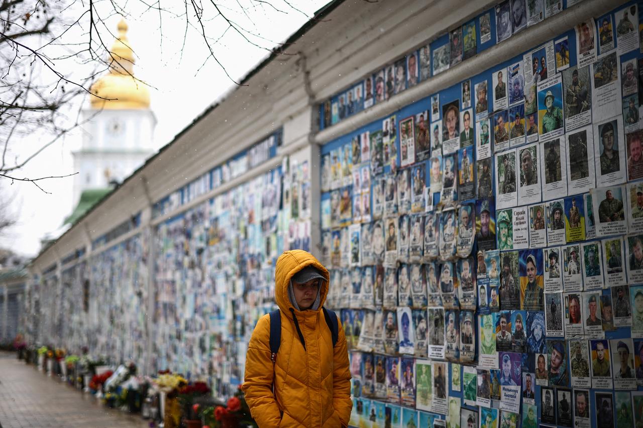A person walks past The Wall of Remembrance of the Fallen for Ukraine in Kyiv on February 25, 2026, amid the Russian invasion of Ukraine. (AFP Photo)