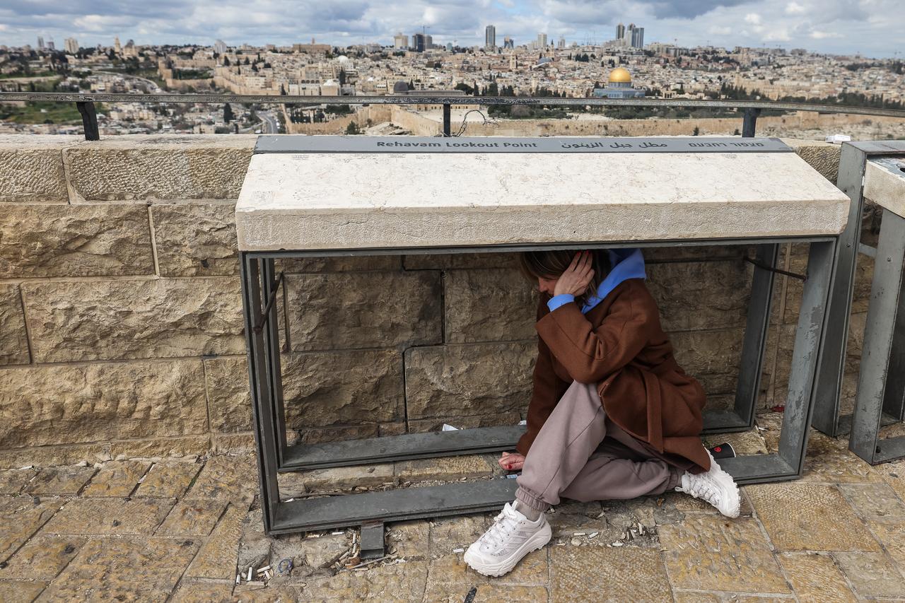 A person takes shelter as sirens sounded in Jerusalem on February 28, 2026, following the announcement that Israel had launched a “preemptive strike” on Iran. (AFP Photo)