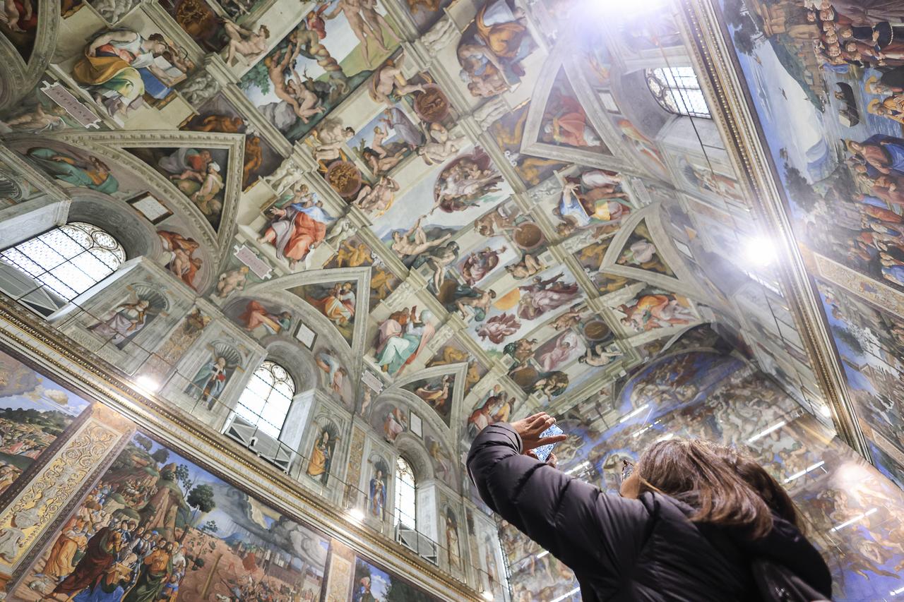 A visitor photographs the frescoed ceiling of the Sistine Chapel during restoration activity surrounding Michelangelo’s The Last Judgement, Feb. 28, 2026. (AA Photo)