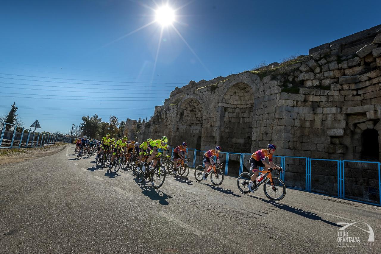 Cyclists push forward under clear skies during a Tour of Antalya stage showcasing the region’s historic landscape. (Photo via Tour of Antalya)