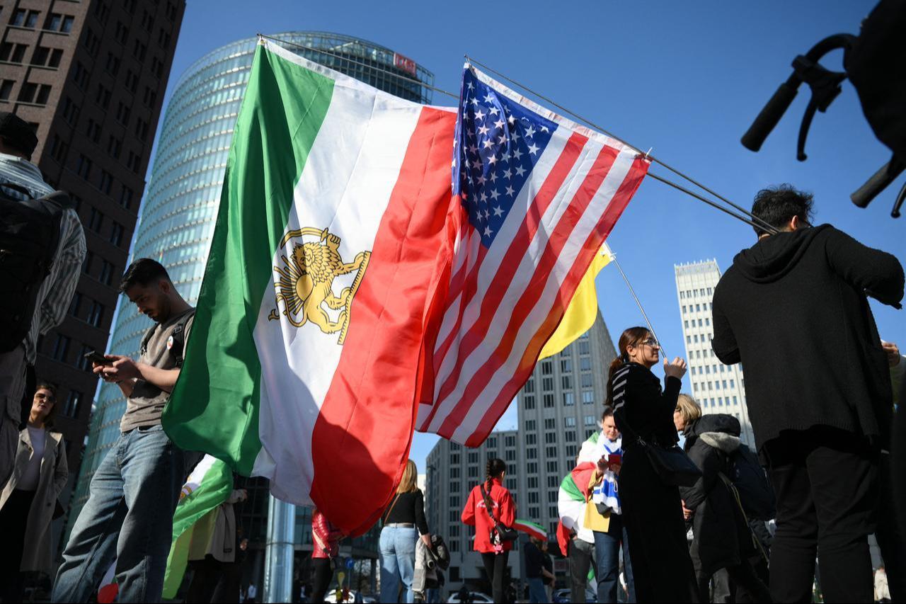 People protest with Iranian pre-revolution Lion and Sun flags and United States' flags during a demonstration "Freedom for Iran" at the Potsdamer Platz square in Berlin, Germany, Feb. 28, 2026. (AFP Photo)