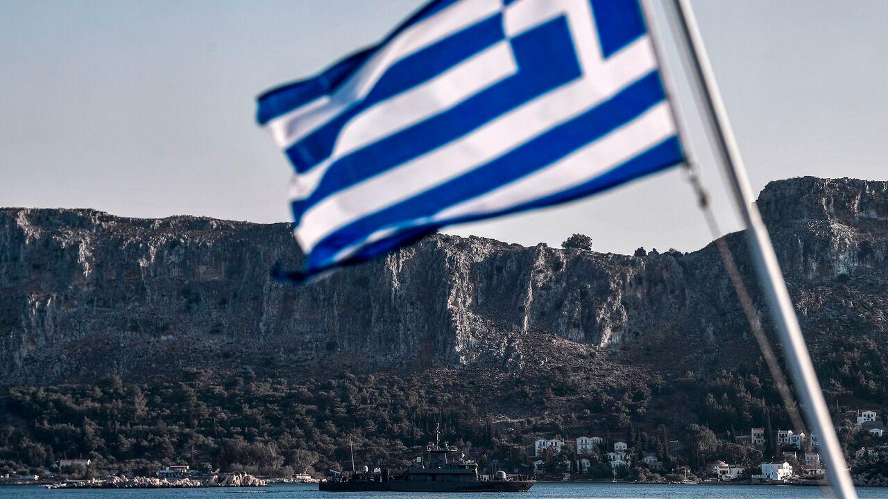 The Greek Navy Roussen or Super Vita class Fast Missile Patrol Boat P 71 HS Ritsos patrols off the tiny island of Meis in front of a Greek flag, August 28, 2020. (AFP Photo)