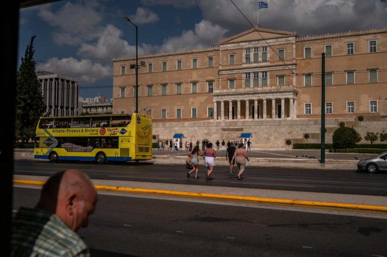People walk by the Greek parliament building in Athens, on August 8, 2022. (AFP Photo)