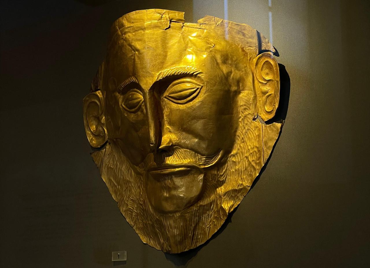 The famous gold death-mask, known as the "mask of Agamemnon," displayed in a dimly lit gallery at the National Archaeological Museum, one of the institution’s most recognized artifacts, July 24, 2025. (Photo by Koray Erdogan/Türkiye Today)