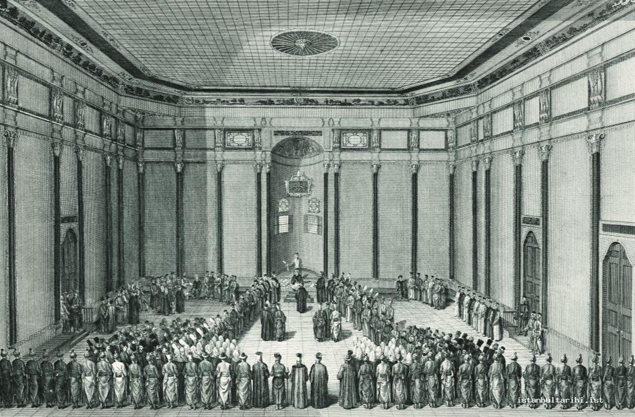 The Council of the Grand Vizier. The illustration shows the grand vizier seated at the center, surrounded by high-ranking officials and bureaucrats, each wearing robes and headgear that indicate rank and function. The scene captures the ceremonial hierarchy of Ottoman administration, highlighting how clothing, posture, and spatial arrangement conveyed authority and status in the empire’s capital. Source: Istanbul Tarihi