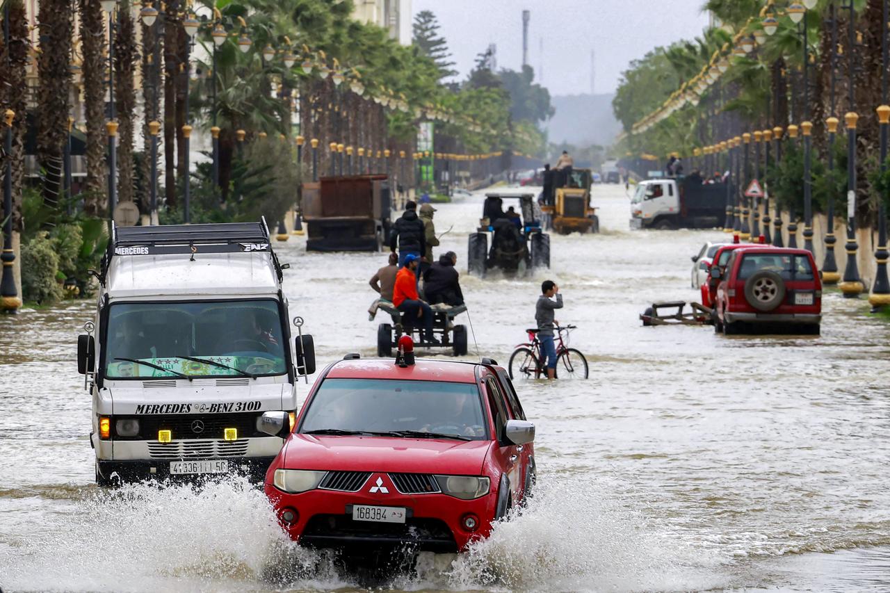 Vehicles move along an inundated main street in Morocco's northwestern city of Ksar el-Kebir on January 29, 2026. (AFP)