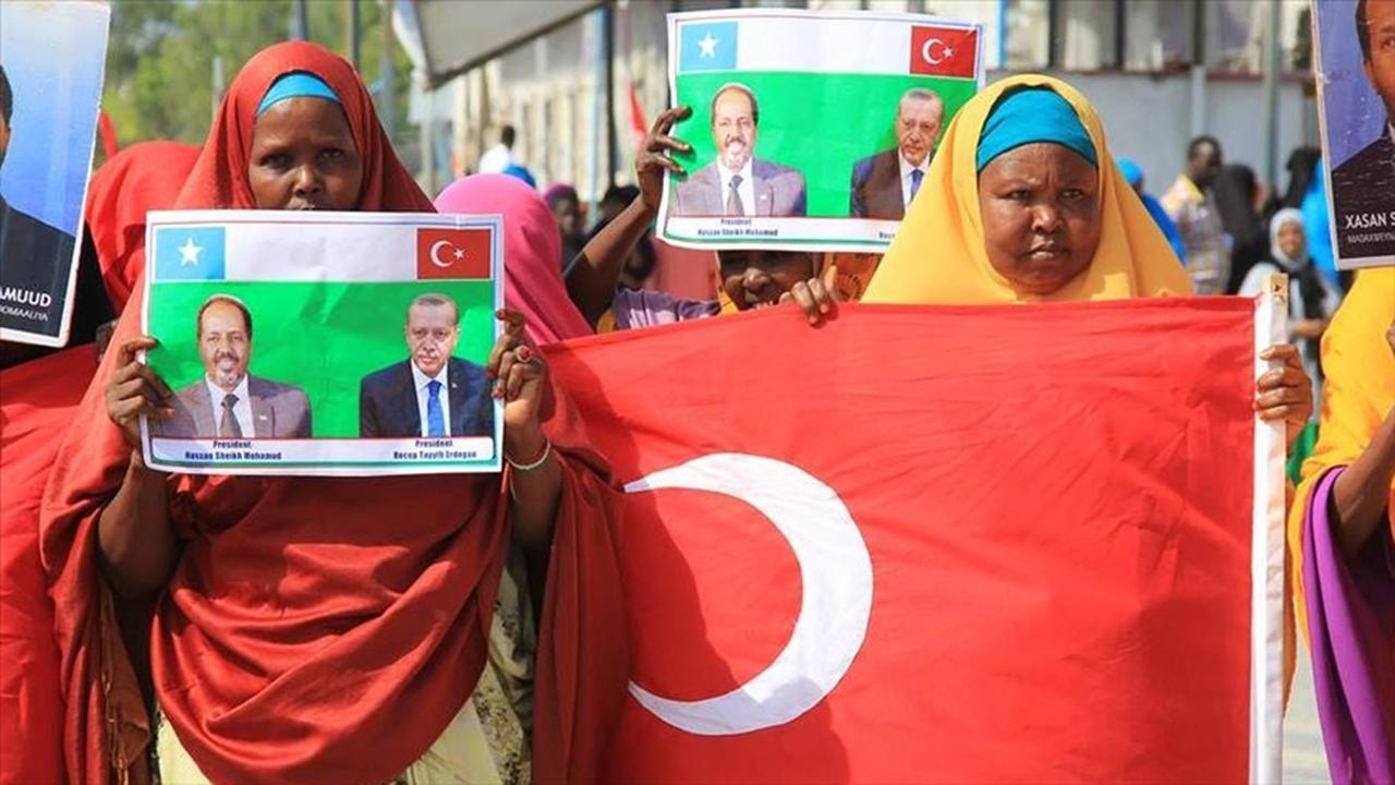 Somalians hold Turkish flag and pictures of Somalian President Hassan Sheikh Mohamud, Turkish President Recep Tayyip Erdogan in Somalia, date and time undisclosed. (AA Photo)