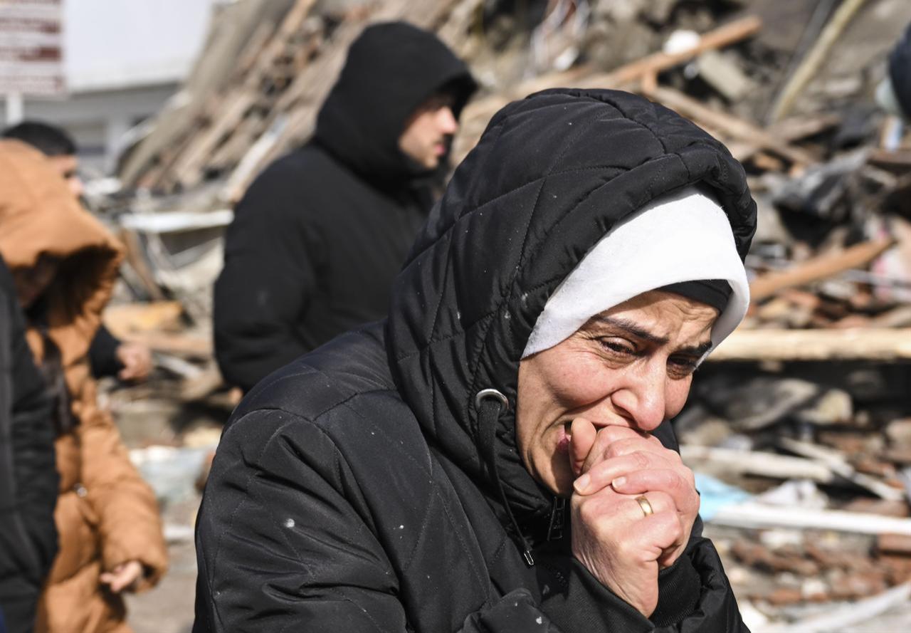 A woman grieves near collapsed building as search and rescue efforts continue at the collapsed Iskenderun State Hospital, Türkiye on February 7, 2023. (AA Photo)