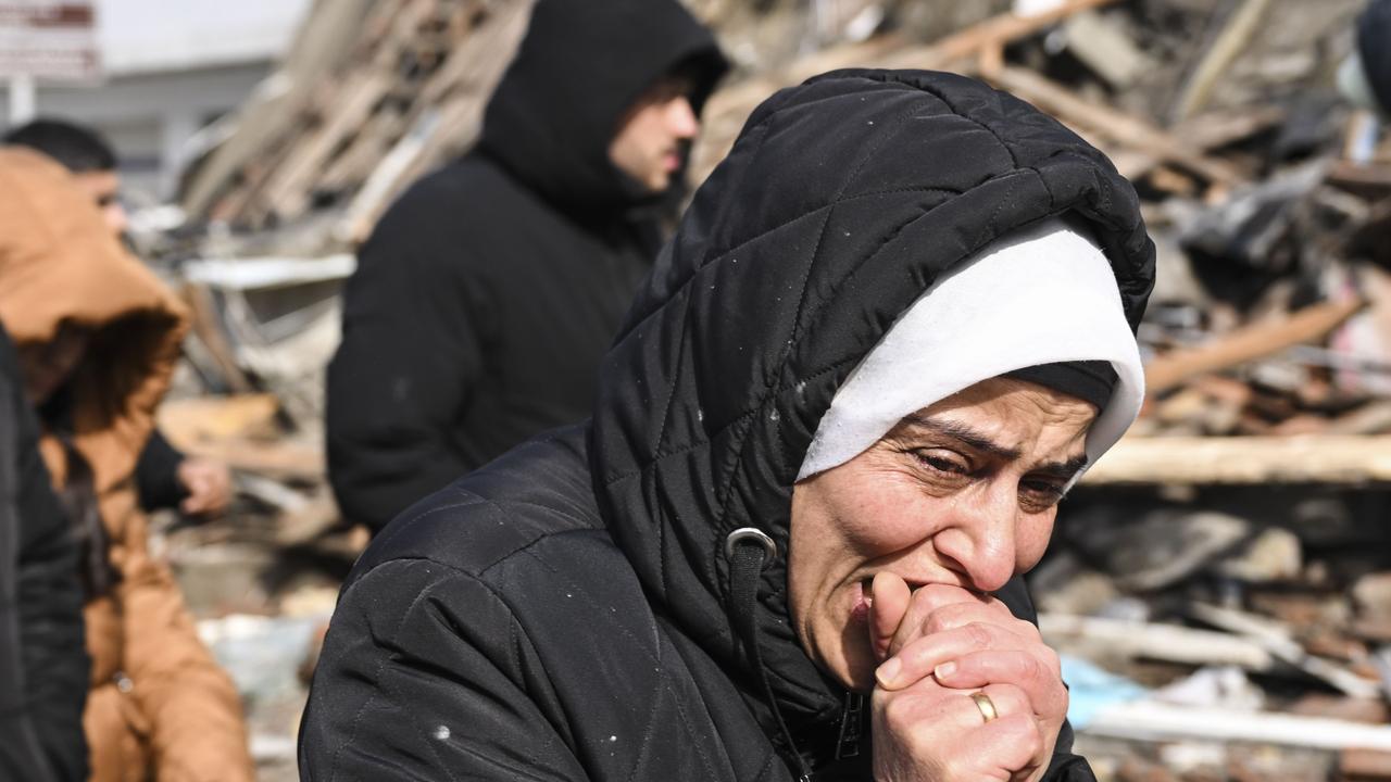 A woman grieves near collapsed building as search and rescue efforts continue at the collapsed Iskenderun State Hospital, Türkiye, February 7, 2023. (AA Photo)