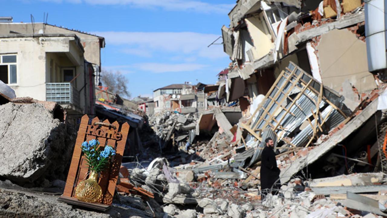 A framed prayer and flowers stand amid collapsed buildings in one of the hardest-hit neighborhoods, Hatay, Türkiye, February 7, 2023. (AA Photo)