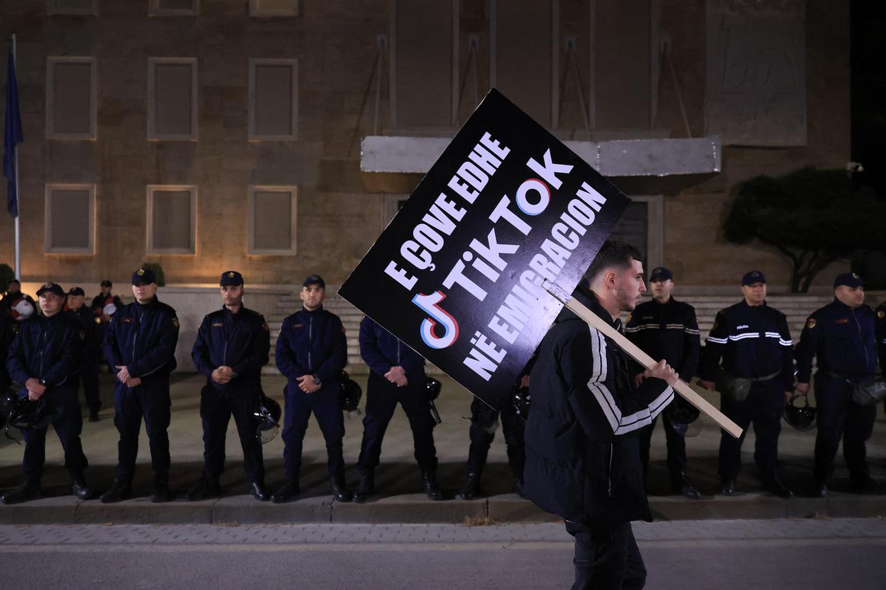 A protester holds a placard in front of a police cordon during a protest against the closure of TikTok in front of the Prime Minister's office in Tirana on March 15, 2025. (AFP File Photo)