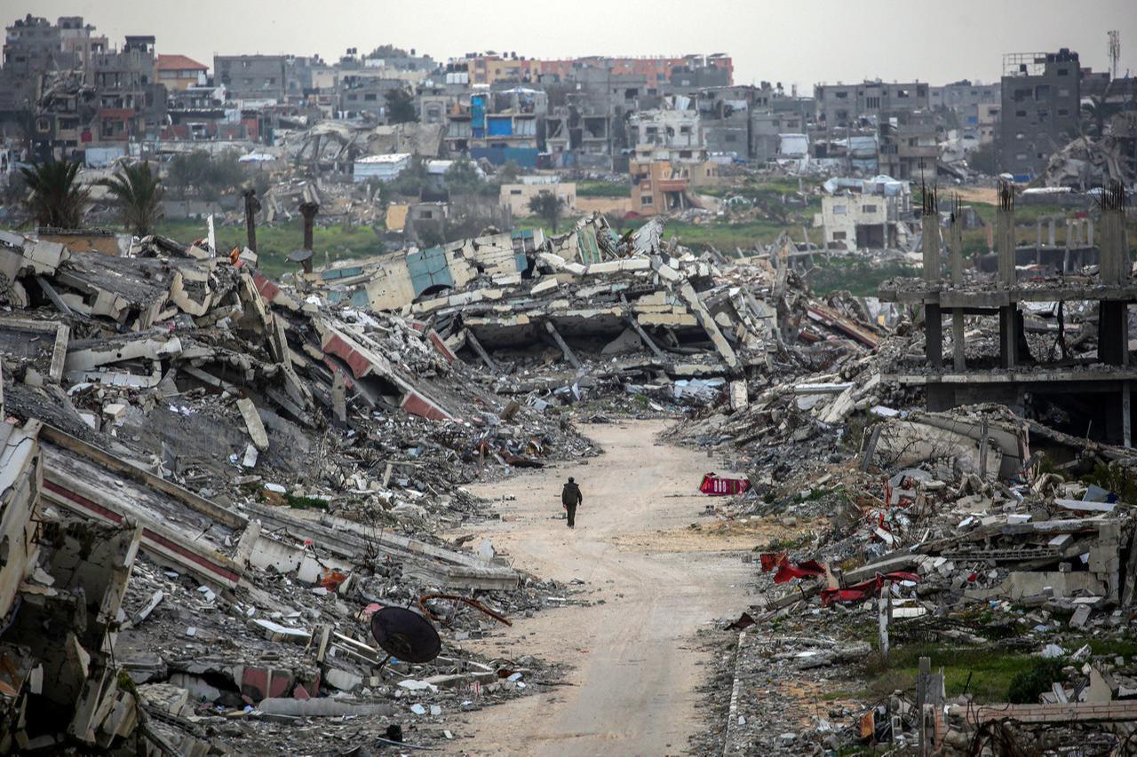 A man walks along a street past the rubble of destroyed buildings in the Zahra neighbourhood, southwest of Nuseirat in the central Gaza Strip, February 6, 2026. (AFP Photo)