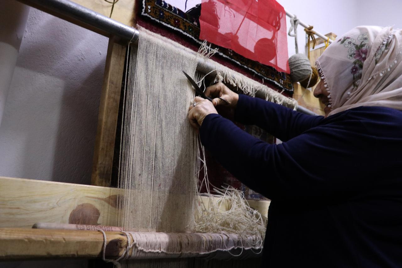 A woman carefully cuts threads while weaving a traditional carpet in Yahyali, Kayseri, central Türkiye, Feb. 7, 2026. (AA Photo)