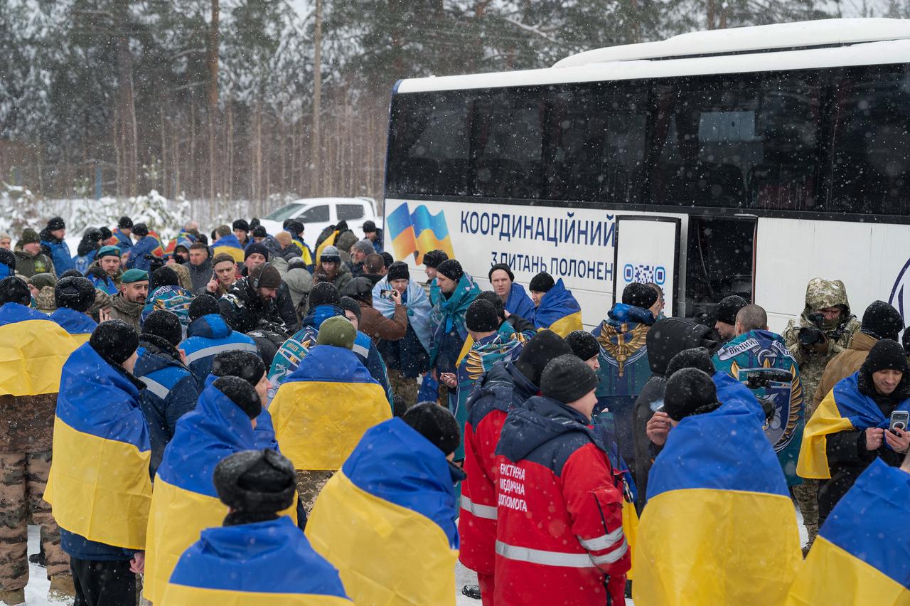 Photo shows Ukrainian prisoners of war (POW) released from Russian captivity draped with flags of Ukraine following a prisoner exchange at an undisclosed location in Ukraine, Feb. 5, 2026. (Photo by Handout/Ukrainian Presidential Service/AFP)