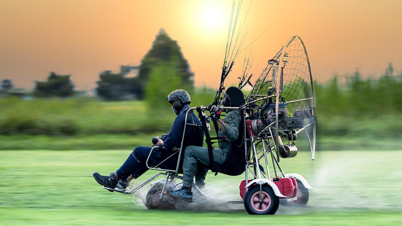 Two men preparing for paramotor flight. (Adobe Stock Photo)
