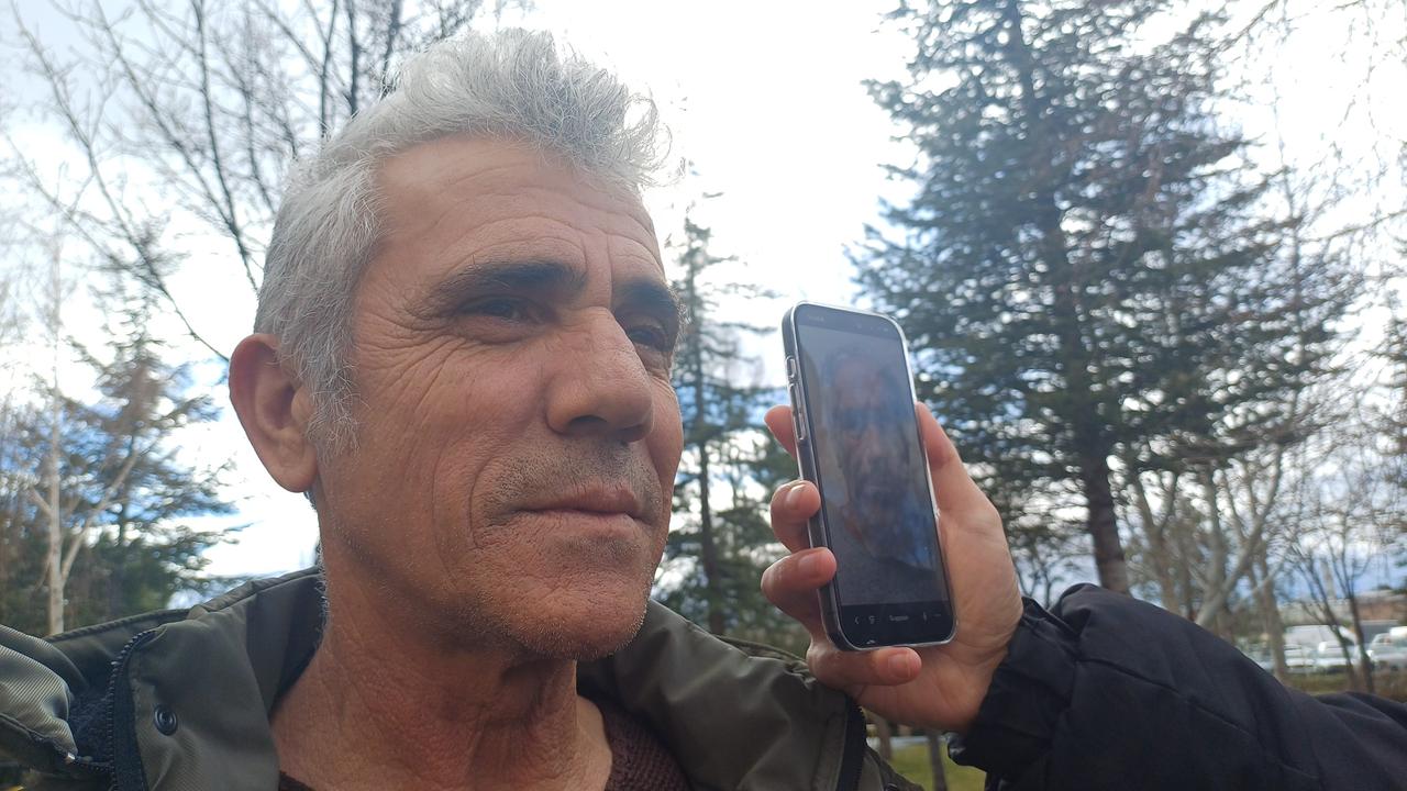 Turkish man poses in a public park while a phone screen next to him displays a photograph of Jeffrey Epstein. (IHA Photo)